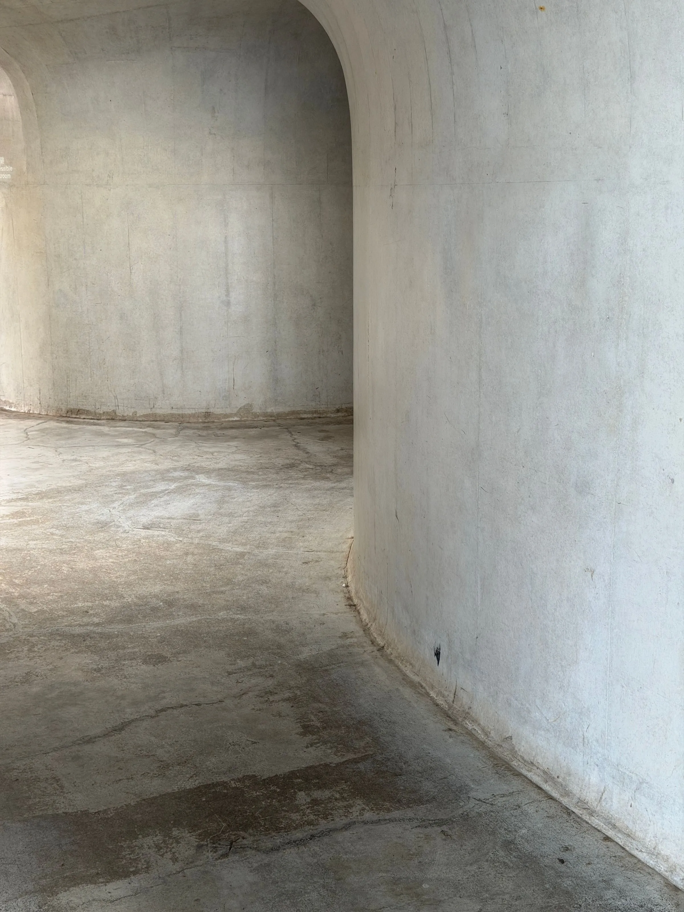 A plain curved concrete wall.